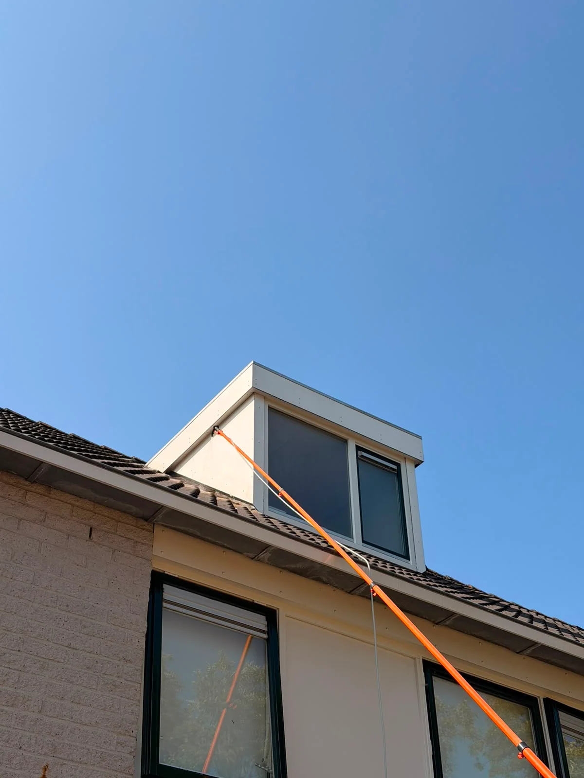 Schoon gereinigde dakkapel met telescoopstok, uitgevoerd door Spat Reiniging
